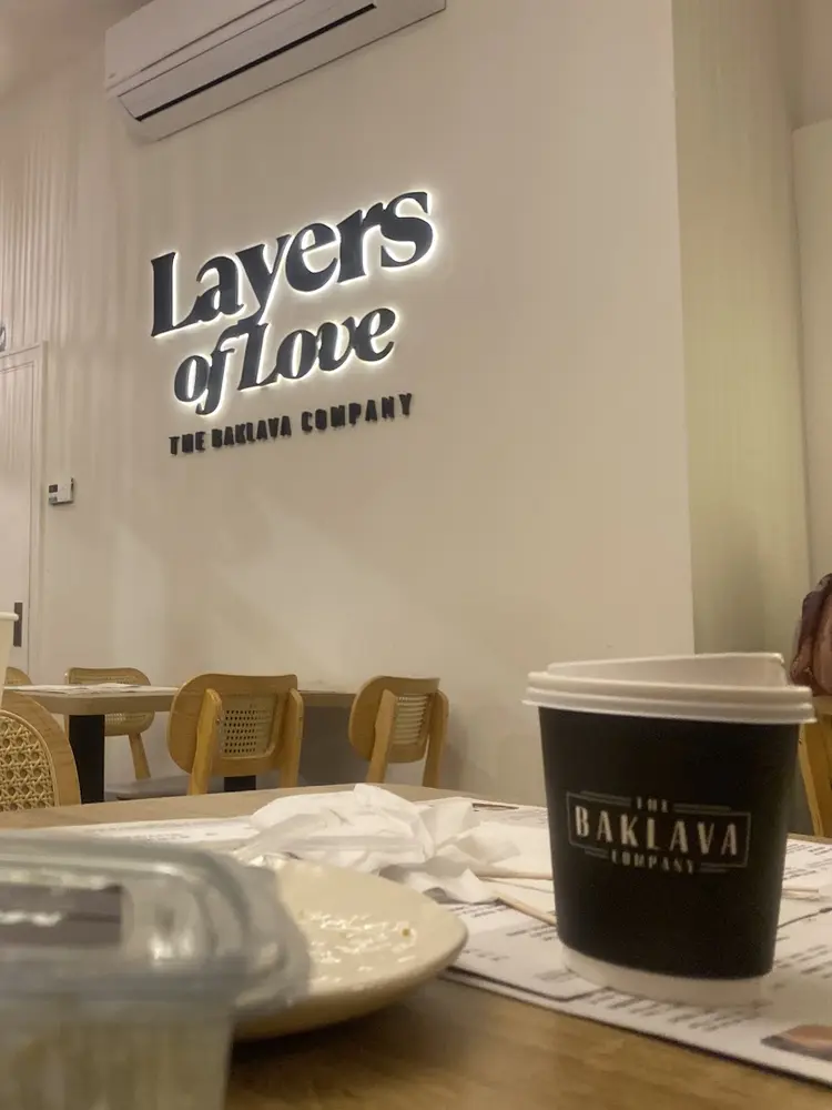 Illuminated Layers of Love sign above The Baklava Company lettering in the cafe seating area